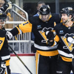 Pittsburgh Penguins' Evgeni Malkin (71) celebrates with Kris Letang (58) and Sidney Crosby (87) after scoring against the Arizona Coyotes during the second period of an NHL hockey game Thursday, Oct. 13, 2022, in Pittsburgh. (AP Photo/Keith Srakocic)