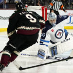 Winnipeg Jets goaltender David Rittich (33) slides over to make a save against Arizona Coyotes right wing Clayton Keller (9) during the first period of an NHL hockey game at Mullett Arena in Tempe, Ariz., Friday, Oct. 28, 2022. (AP Photo/Ross D. Franklin)