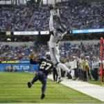 Seattle Seahawks wide receiver Marquise Goodwin (11) catches a pass for a touchdown during the first half of an NFL football game against the Los Angeles Chargers Sunday, Oct. 23, 2022, in Inglewood, Calif. Los Angeles Chargers cornerback J.C. Jackson (27) falls with an injury. (AP Photo/Marcio Jose Sanchez)