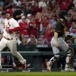 
              St. Louis Cardinals' Nolan Arenado, left, scores past Pittsburgh Pirates catcher Jason Delay during the second inning of a baseball game Saturday, Oct. 1, 2022, in St. Louis. (AP Photo/Jeff Roberson)
            