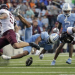 North Carolina wide receiver Josh Downs (11) fumbles the ball after getting hit by Virginia Tech linebacker Will Johnson (53) and defensive back Jalen Stroman (26) during the second half of an NCAA college football game in Chapel Hill, N.C., Saturday, Oct. 1, 2022. North Carolina recovered the fumble. (AP Photo/Chris Seward)