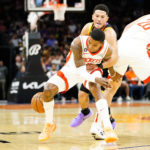 Phoenix Suns' Devin Booker, top, knocks the ball away from Houston Rockets' Kevin Porter Jr., bottom, during the first half of an NBA basketball game, Sunday, Oct. 30, 2022, in Phoenix. (AP Photo/Darryl Webb)