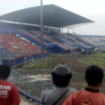 
              People examine the damage following a soccer match stampede at the Kanjuruhan Stadium in Malang, East Java, Indonesia, Sunday, Oct. 2, 2022. Panic at an Indonesian soccer match after police fired tear gas to to disperse supporters invading the pitch left over 100 people dead, mostly trampled to death, police said Sunday. (AP Photo/Hendra Permana)
            