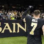 
              New Orleans Saints' Taysom Hill acknowledges the fans as he leaves the field after the team's 39-32 win over the Seattle Seahawks after an NFL football game in New Orleans, Sunday, Oct. 9, 2022. (AP Photo/Gerald Herbert)
            