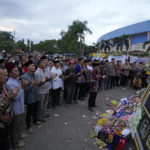 
              Supporters of soccer club Arema FC pray for victims of Saturday's soccer match stampede outside the Kanjuruhan Stadium in Malang, Indonesia, Monday, Oct. 3, 2022. Panic at an Indonesian soccer match Saturday left over 100 people dead, most of whom were trampled to death after police fired tear gas to stop the violence. (AP Photo/Achmad Ibrahim)
            