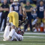 Notre Dame wide receiver Jayden Thomas (83) is flipped by UNLV defensive back BJ Harris (21) during the second half of an NCAA college football game, Saturday, Oct. 22, 2022, in South Bend, Ind. (AP Photo/Marc Lebryk)