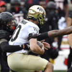 Wake Forest quarterback Sam Hartman is sacked by Louisville defensive back Josh Minkins during the first half of an NCAA college football game in Louisville, Ky., Saturday, Oct. 29, 2022. (AP Photo/Timothy D. Easley)
