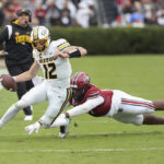 
              Missouri quarterback Brady Cook (12) is pushed out of bounds by South Carolina defensive lineman Tonka Hemingway (91) during the first half of an NCAA college football game on Saturday, Oct. 29, 2022, in Columbia, S.C. (AP Photo/Artie Walker Jr.)
            