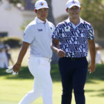 Si Woo Kim, left, and Tom Kim, both of South Korea, walk along the fairway at the ninth hole during the first round of the Shriners Children's Open golf tournament at TPC Summerlin, Thursday, Oct. 6, 2022, in Las Vegas. (AP Photo/Ronda Churchill)