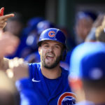Chicago Cubs' David Bote yells as he high-fives teammates in the dugout after hitting a three-run home run during the second inning of a baseball game against the Cincinnati Reds in Cincinnati, Wednesday, Oct. 5, 2022. (AP Photo/Aaron Doster)