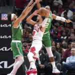 Boston Celtics' Derrick White (9) and Al Horford pressure Chicago Bulls' Zach LaVine during the first half of an NBA basketball game Monday, Oct. 24, 2022, in Chicago. (AP Photo/Charles Rex Arbogast)