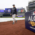 New York Yankees first base coach Travis Chapman walks on the field as a light rain falls before Game 4 of an American League Championship baseball series between the New York Yankees and the Houston Astros, Sunday, Oct. 23, 2022, in New York. (AP Photo/John Minchillo)
