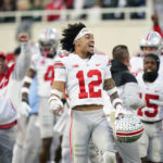 
              Ohio State safety Lathan Ransom (12) reacts after teammate Gee Scott Jr. scored on a 2-yard pass reception during the second half of an NCAA college football game against Michigan State, Saturday, Oct. 8, 2022, in East Lansing, Mich. (AP Photo/Carlos Osorio)
            