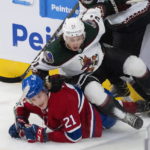 Arizona Coyotes' Troy Stecher (51) falls on Montreal Canadiens' Kaiden Guhle (21) during first-period NHL hockey game action in Montreal, Thursday, Oct. 20, 2022. (Paul Chiasson/The Canadian Press via AP)