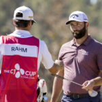 Jon Rahm, of Spain, hands a club to his caddie after putting on the first green during the final round of the CJ Cup golf tournament Sunday, Oct. 23, 2022, in Ridgeland, S.C. (AP Photo/Stephen B. Morton)
