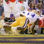 
              Mississippi running back Quinshon Judkins, right, leaps for a touchdown against LSU safety Joe Foucha (13) during the first half of an NCAA college football game in Baton Rouge, La., Saturday, Oct. 22, 2022. (AP Photo/Matthew Hinton)
            