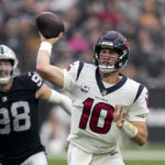 Houston Texans quarterback Davis Mills, right, throws a pass under pressure from Las Vegas Raiders defensive end Maxx Crosby during the second half of an NFL football game Sunday, Oct. 23, 2022, in Las Vegas. (AP Photo/John Locher)