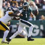 Philadelphia Eagles quarterback Jalen Hurts (1) avoids a tackle from Pittsburgh Steelers Khalil Davis during the first half of an NFL football game between the Pittsburgh Steelers and Philadelphia Eagles, Sunday, Oct. 30, 2022, in Philadelphia. (AP Photo/Matt Slocum)