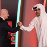 FILE - FIFA President Gianni Infantino, left, and Emir of Qatar Sheikh Tamim bin Hamad Al Thani shake hands before the 2022 soccer World Cup draw at the Doha Exhibition and Convention Center in Doha, Qatar, Friday, April 1, 2022. World Cup fans could bring political tensions to quiet Qatar. (AP Photo/Hassan Ammar, File)