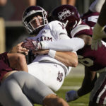 Texas A&M quarterback Max Johnson is tackled by Mississippi State defenders during the first half of an NCAA college football game in Starkville, Miss., Saturday, Oct. 1, 2022. (AP Photo/Rogelio V. Solis)