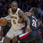 Los Angeles Lakers forward LeBron James, left, drives around Portland Trail Blazers forward Justise Winslow during the first half of an NBA basketball game Sunday, Oct. 23, 2022, in Los Angeles. (AP Photo/Alex Gallardo)