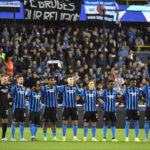 Players of Club Brugge stand for a moment of silence to remember the victims of the Indonesia stadium tragedy prior to the Champions League Group B soccer match between Club Brugge and Atletico Madrid at the Jan Breydel stadium in Bruges, Belgium, Tuesday, Oct. 4, 2022. (AP Photo/Geert Vanden Wijngaert)