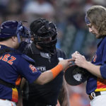 
              From left to right, Houston Astros catcher Christian Vazquez, umpire Jim Wolf and relief pitcher Ryne Stanek adjust the PitchCom system during the seventh inning of a baseball game against the Tampa Bay Rays, Sunday, Oct. 2, 2022, in Houston. (AP Photo/Kevin M. Cox)
            