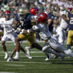 Notre Dame running back Audric Estime (7) stiff arms UNLV defensive back Johnathan Baldwin (3) during the first quarter of an NCAA college football game, Saturday, Oct. 22, 2022, in South Bend, Ind. (AP Photo/Marc Lebryk)