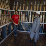 
              Azhar Bhat, a Kashmir man tosses a ball with a bat to demonstrate its quality to a customer inside his showroom in Sangam, south of Srinagar, Indian controlled Kashmir, Sept. 22, 2022. Kashmir’s dwindling willow plantations are impacting the region’s famed cricket bat industry and risking the supply of cricket bats in India, where the sport is hugely followed. The industry employs more than 10,000 people and manufactures nearly a million bats a year. (AP Photo/Dar Yasin)
            