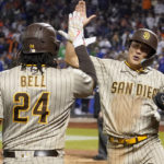 San Diego Padres shortstop Ha-Seong Kim, right, celebrates with first baseman Josh Bell (24) after scoring on a hit by Juan Soto against the New York Mets during the eighth inning of Game 3 of a National League wild-card baseball playoff series, Sunday, Oct. 9, 2022, in New York. (AP Photo/John Minchillo)