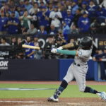 Seattle Mariners' J.P. Crawford hits a three-run double against the Toronto Blue Jays during the eighth inning of Game 2 of a baseball AL wild-card playoff series Saturday, Oct. 8, 2022, in Toronto. (Nathan Denette/The Canadian Press via AP)