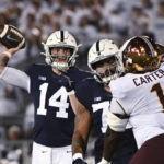 Penn State quarterback Sean Clifford (14) throws a pass to wide receiver Parker Washington, while Minnesota defensive lineman Trill Carter (1) is blocked during the first half of an NCAA college football game Saturday, Oct. 22, 2022, in State College, Pa. (AP Photo/Barry Reeger)