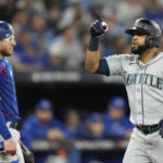 Seattle Mariners designated hitter Carlos Santana, right, celebrates after his three-run home run against the Toronto Blue Jays during the sixth inning of Game 2 of a baseball AL wild-card playoff series Saturday, Oct. 8, 2022, in Toronto. (Frank Gunn/The Canadian Press via AP)
