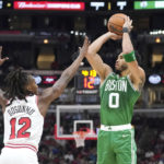 Boston Celtics' Jayson Tatum (0) shoots as Chicago Bulls' Ayo Dosunmu defends during the first half of an NBA basketball game Monday, Oct. 24, 2022, in Chicago. (AP Photo/Charles Rex Arbogast)