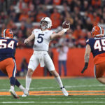 
              Virginia quarterback Brennan Armstrong (5) throws a pass while pressured by Syracuse defensive linemen Jatius Geer (54) and Kevon Darton (45) during the second half of an NCAA college football game Friday, Sept. 23, 2022, in Syracuse, N.Y. Syracuse won 22-20. (AP Photo/Adrian Kraus)
            