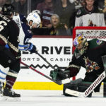 Arizona Coyotes goaltender Karel Vejmelka (70) makes a save on a shot by Winnipeg Jets center Sam Gagner (89) as Coyotes right wing Christian Fischer (36) looks on during the third period of an NHL hockey game at Mullett Arena in Tempe, Ariz., Friday, Oct. 28, 2022. The Jets won 3-2 in overtime. (AP Photo/Ross D. Franklin)