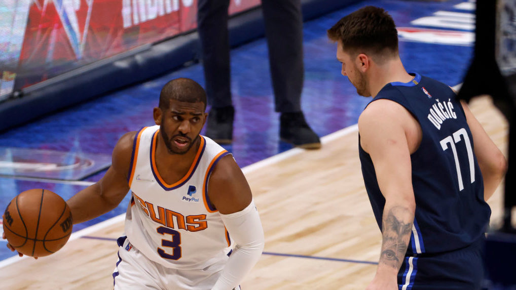 Chris Paul #3 of the Phoenix Suns dribbles the ball against Luka Doncic #77 of the Dallas Mavericks...