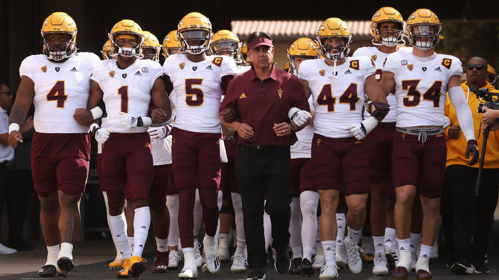 Head coach Shaun Aguano of the Arizona State Sun Devils walks out with the team before the game aga...