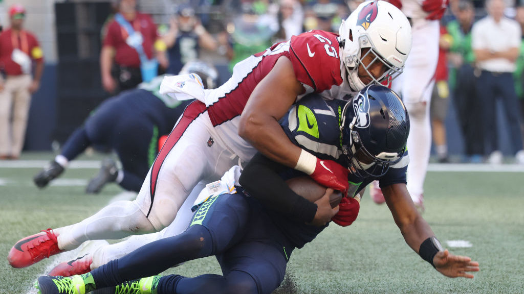 Zaven Collins #25 of the Arizona Cardinals sacks Geno Smith #7 of the Seattle Seahawks during the f...