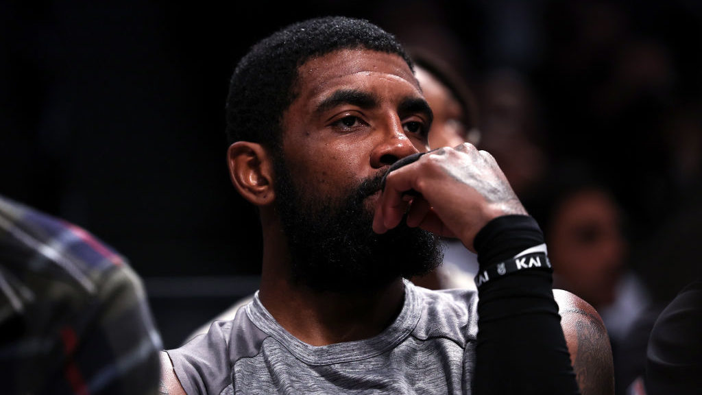 Kyrie Irving #11 of the Brooklyn Nets looks on from the bench during the second quarter of the game...