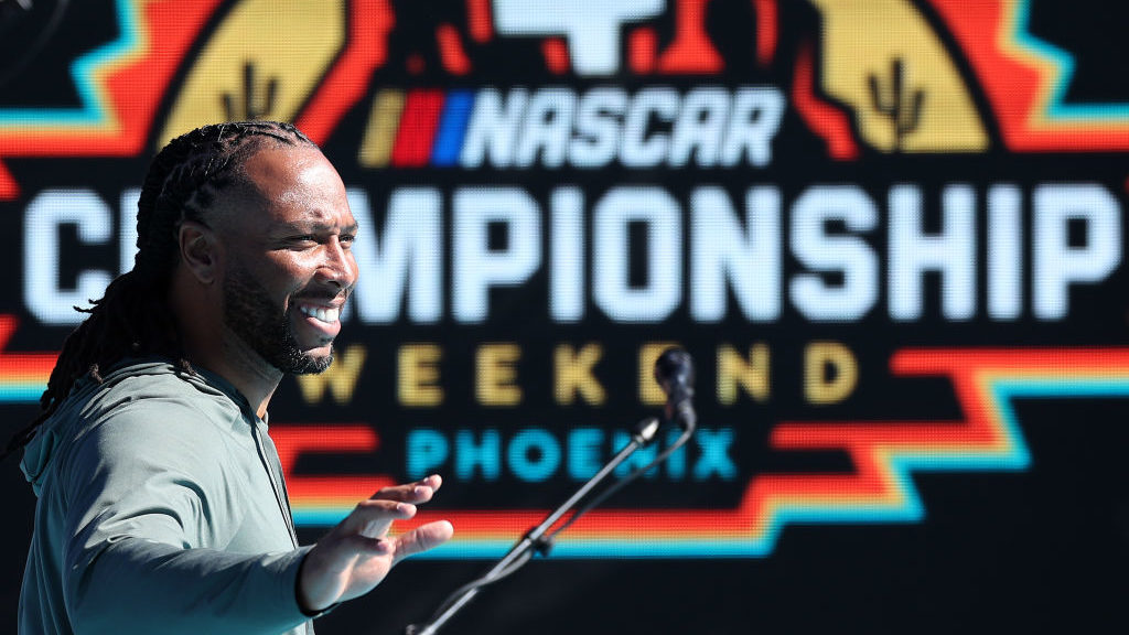 Former NFL player Larry Fitzgerald Jr. waves to fans as he walks onstage prior to the NASCAR fa pri...