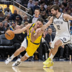 Indiana Pacers guard T.J. McConnell (9) drives the ball against the defense of Brooklyn Nets forward Joe Harris (12) during the second half of an NBA basketball game in Indianapolis, Friday, Nov. 25, 2022. (AP Photo/Doug McSchooler)