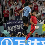South Korea's Lee Kang-in, right, and Uruguay's Matias Vina go for a header during the World Cup group H soccer match between Uruguay and South Korea, at the Education City Stadium in Al Rayyan , Qatar, Thursday, Nov. 24, 2022. (AP Photo/Martin Meissner)