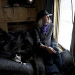 
              Karole Denning looks out the window of his 103-square-foot apartment in Minturn, Colo., on Oct. 25, 2022. Denning, who pays $900 a month in rent, commutes 10 minutes west to one job, at a radio station he runs out of the basement of a restaurant, and 20 minutes east to another job as a pizza chef. Minturn is a more affordable option for people who live near the ski resort town of Vail, which is about 5 miles to the east. (AP Photo/Thomas Peipert)
            