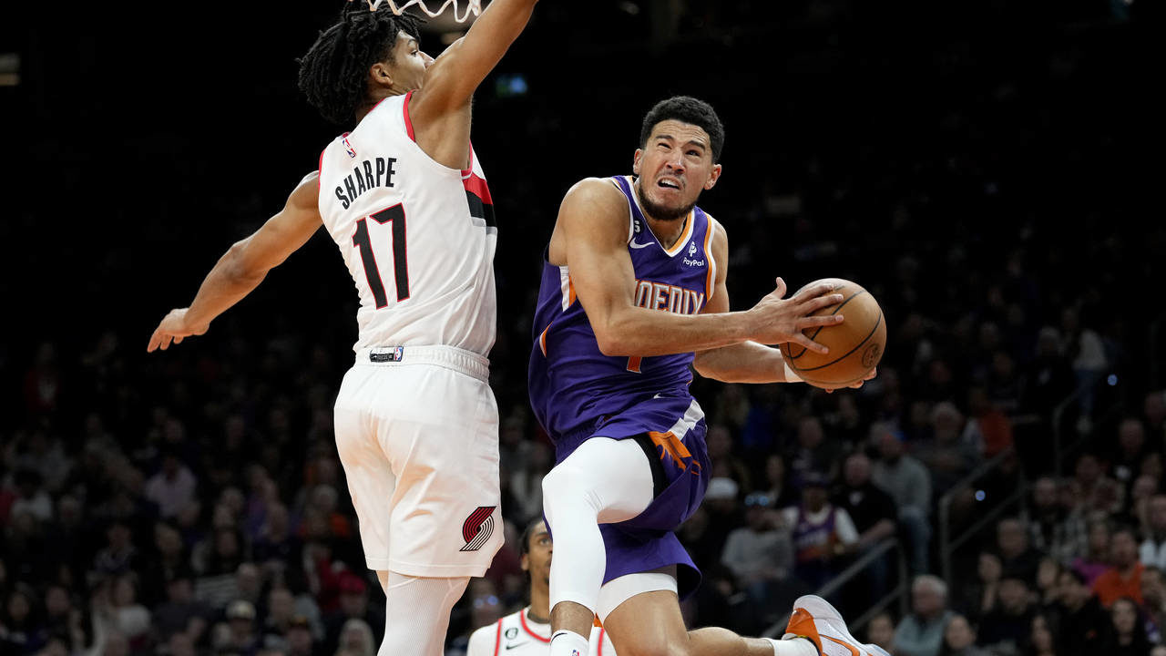 Phoenix Suns guard Devin Booker (1) shoots around Portland Trail Blazers guard Shaedon Sharpe (17) ...