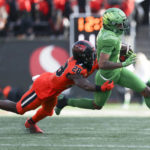 Oregon wide receiver Troy Franklin, right, is brought down by Oregon State defensive back Kitan Oladapo (28) during the first half of an NCAA college football game on Saturday, Nov 26, 2022, in Corvallis, Ore. (AP Photo/Amanda Loman)