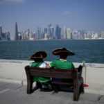 
              Two Mexican soccer fans sit on a bench on Doha corniche, in Monday, Nov. 21, 2022. (AP Photo/Natacha Pisarenko)
            
