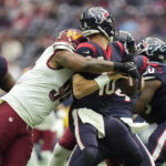 
              Houston Texans quarterback Davis Mills (10) is sacked by Washington Commanders defensive end Montez Sweat (90) during the first half of an NFL football game Sunday, Nov. 20, 2022, in Houston. (AP Photo/Eric Christian Smith)
            