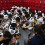 
              Crestwood High School football player Adam Berry (19) leads a muslim prayer before a game in Melvindale, Mich., Friday, Sept. 23, 2022. (AP Photo/Paul Sancya)
            