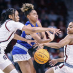 Hampton guard Victoria Mason, center, battles South Carolina guards Zia Cooke, left, and Kierra Fletcher, right, for control of the ball during the first quarter of an NCAA college basketball game in Columbia, S.C., Sunday, Nov. 27, 2022. (AP Photo/Nell Redmond)